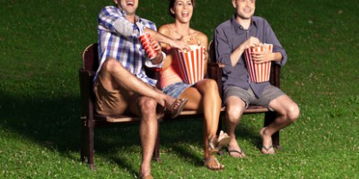 Trois amis regardant un film en plein air
